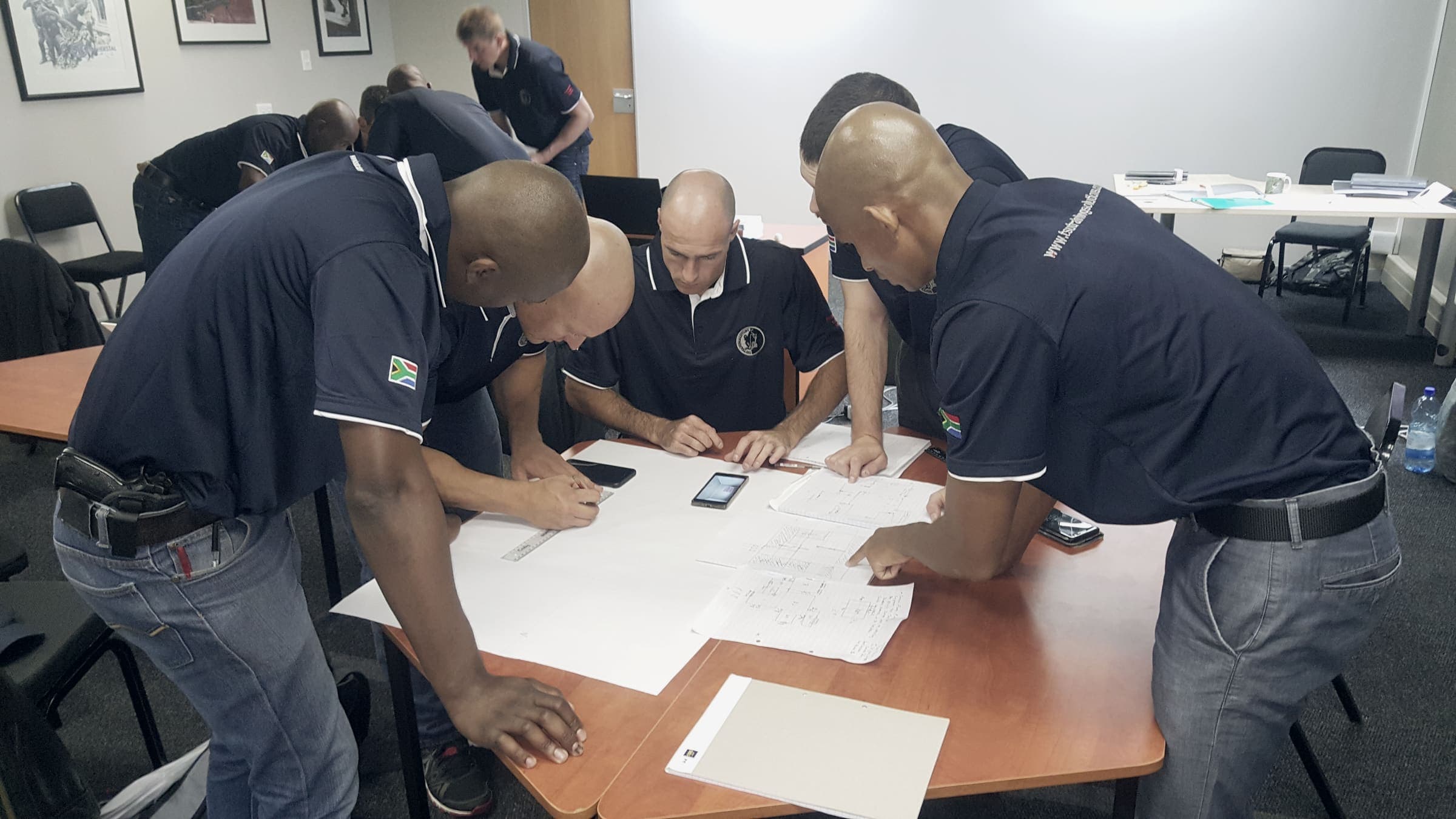 Team in navy shirts planning over documents at a table