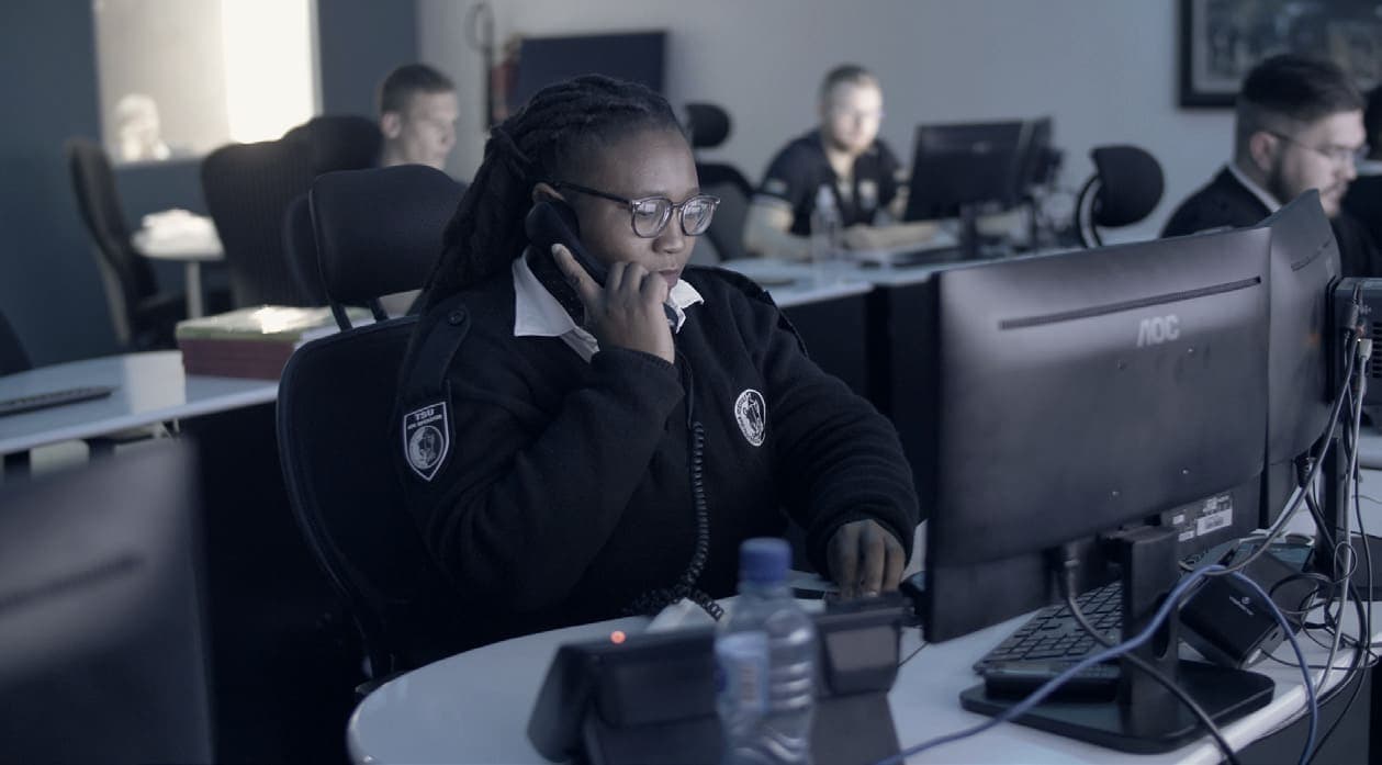 Control room operators in TSU-branded jackets, operator on phone (newer fit-out)