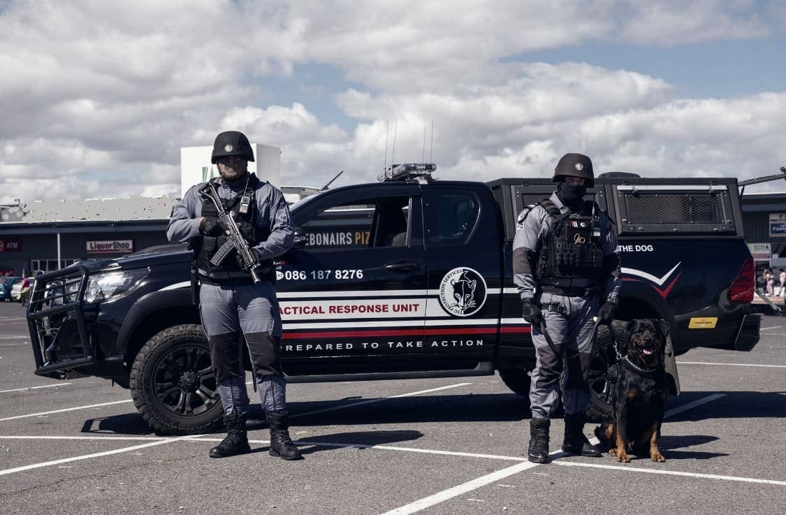 Tactical Response Unit bakkie with two armed officers and a Rottweiler